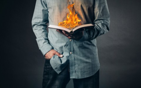  man reading a book on fire
