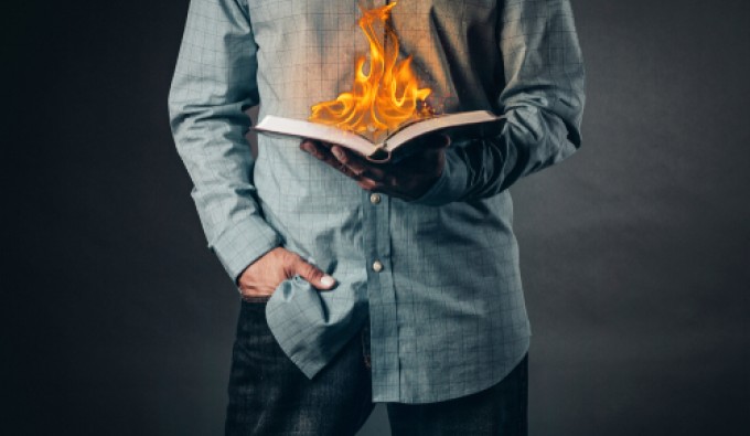 man reading a book on fire