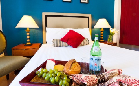 charcuterie board and sparkeling water on bed of single room