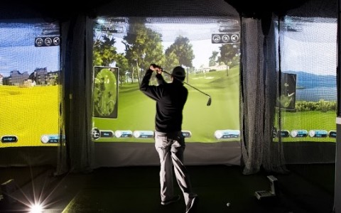 man teeing off at virtual golf