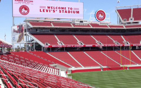 Levi Stadium with sign welcoming fans and red seats and green field