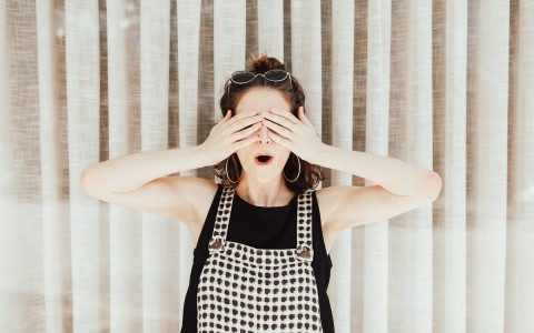 Surprised woman covering her eyes 