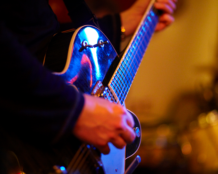 close up of a person playing the guitar 