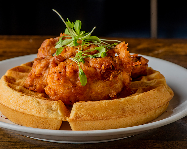 side view of chicken and waffles on a plate 