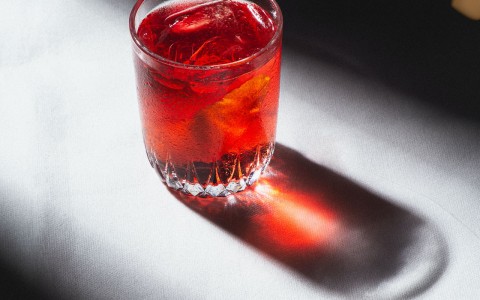 red cocktail standing alone in the sun light
