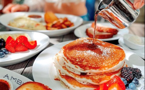 maple syrup being poured on pancakes