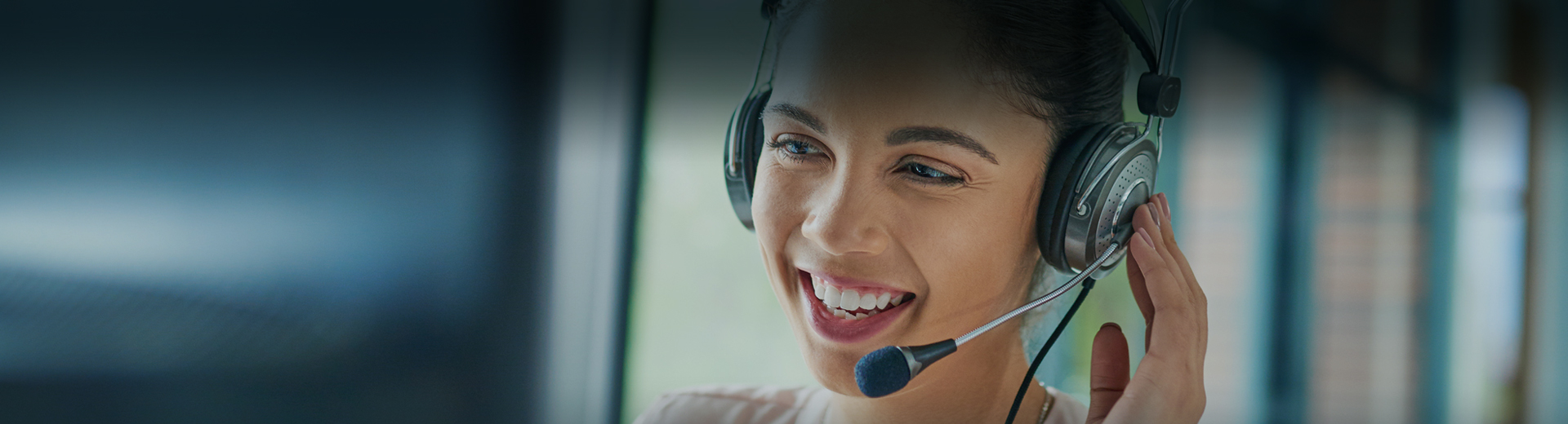 closeup photo of a woman smiling while she is taking a call with her earphones 