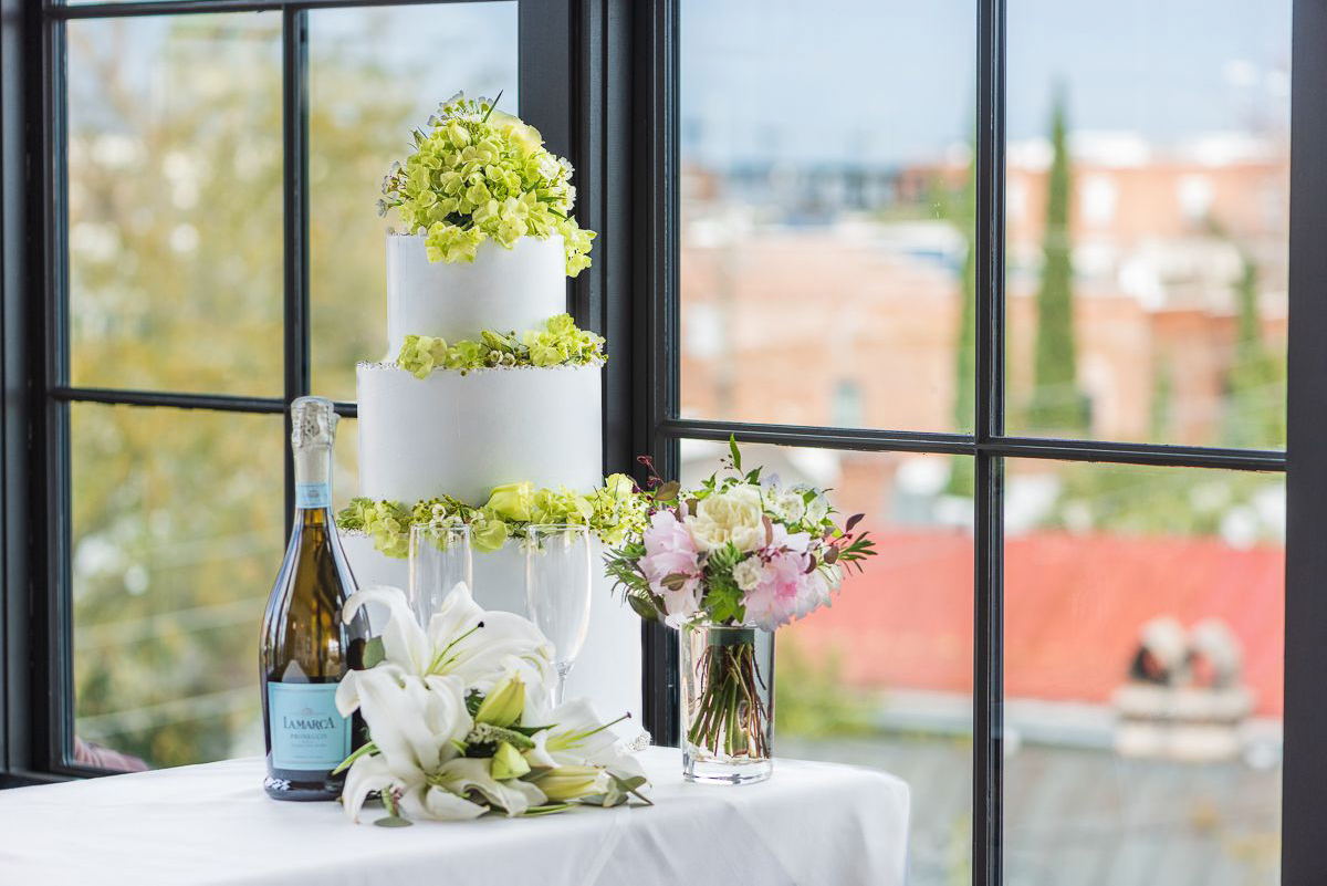 a table in front of a window with a wedding cake 