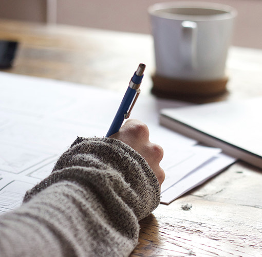 close up image a person writing with a pen