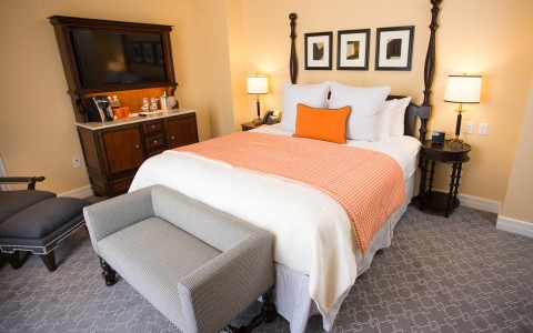 bedroom with a grey couch and orange accents 