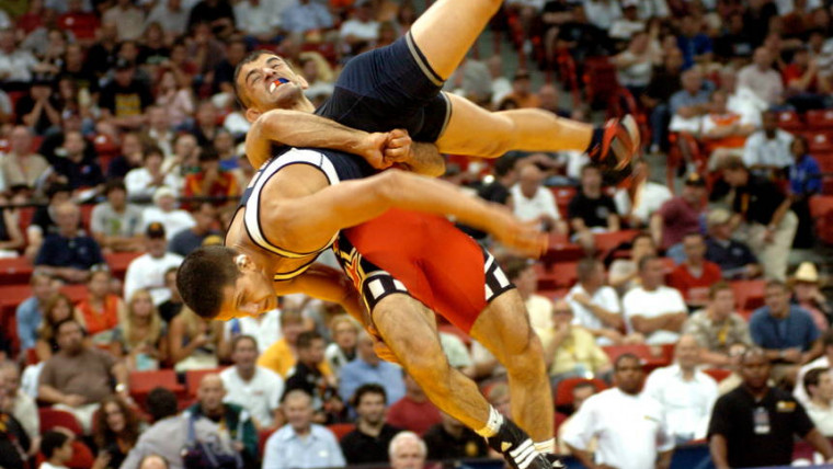 One wrestler tossing another down