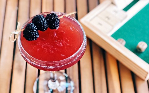 red cocktail with black berries