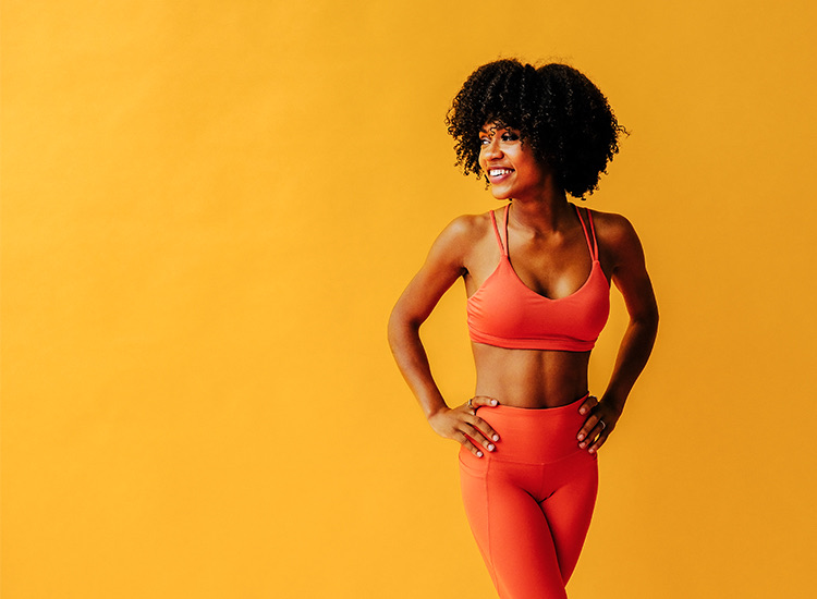 someone standing in front of an orange wall with yoga clothing on