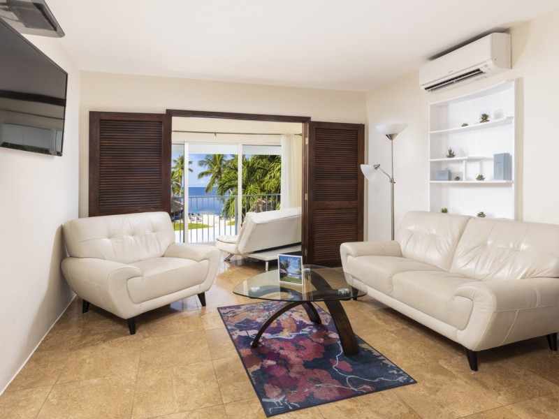living room with tan couches and doors separating sun room