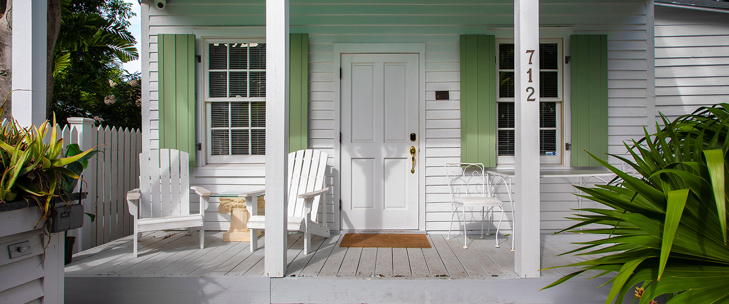 front deck of a house with two white chairs