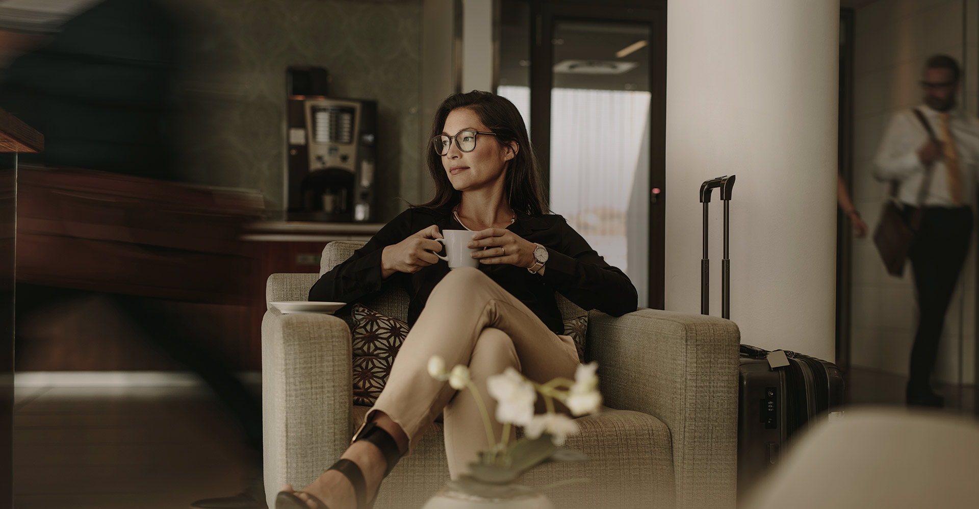 sited woman holding a cup of coffee at a lobby 