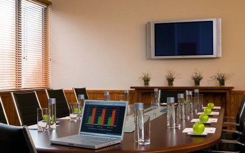view of smaller meeting space with board room table and laptop