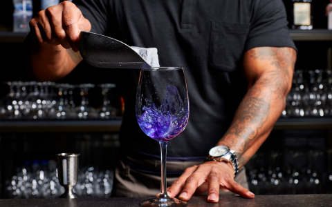 bartender mixing a blue and purple beverage