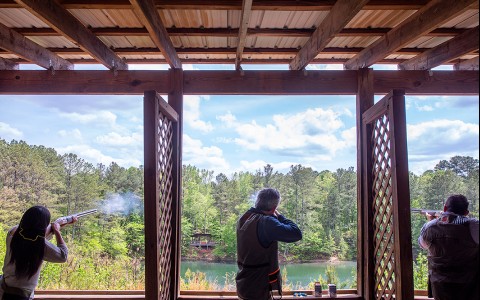 three people shooting in an outdoor range