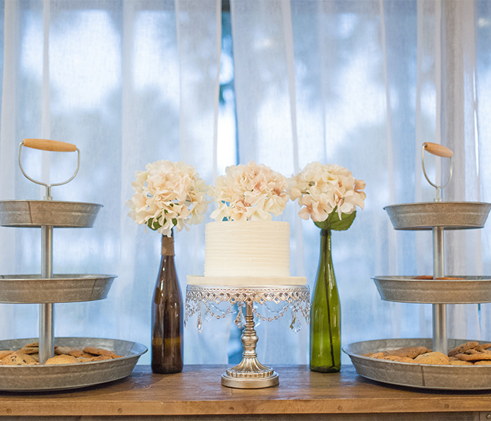 a wedding cake setup with towers of cookies to the left and right