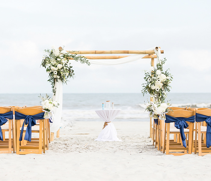 an outdoor wedding ceremony with the ocean in the background