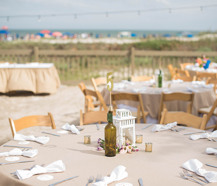 tables set up on the beach for an outdoor event during the day