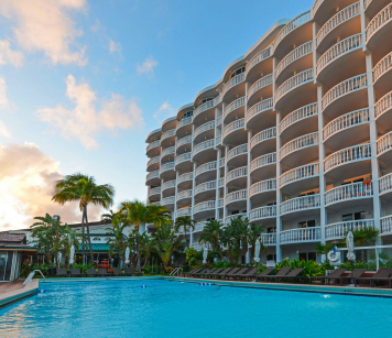 Property building next to swimming pool with palm trees