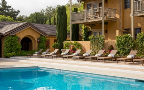 Pool lined with brown lounge chairs