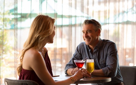 Man and woman drinking a beer and a cocktail