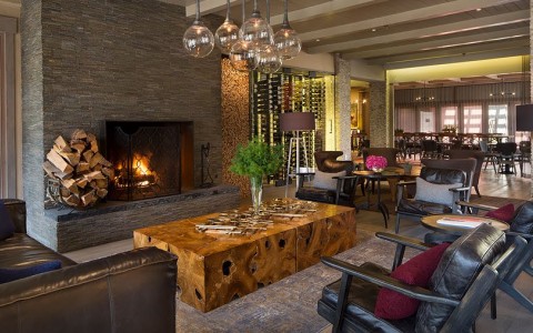 seating area with large fireplace looking into the dining room and wine room