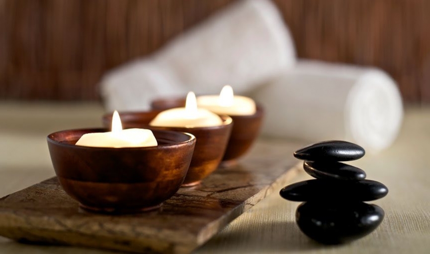 three lit candles in copper holders in the spa