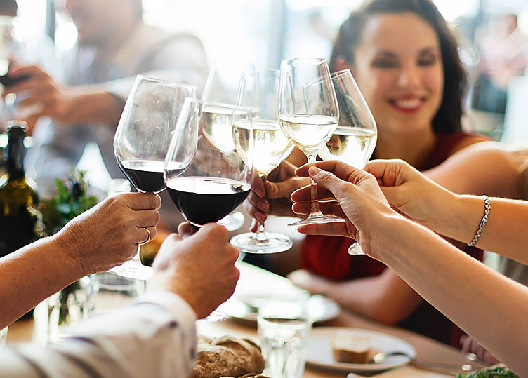 women and men toasting wine glasses of red and white wine