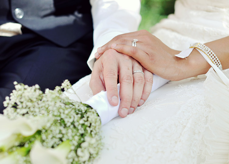 a man in a suit holding hands with a woman in a wedding dress