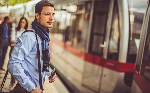 A man in a scarf waiting to get on a train at the Bart Caltrain Station