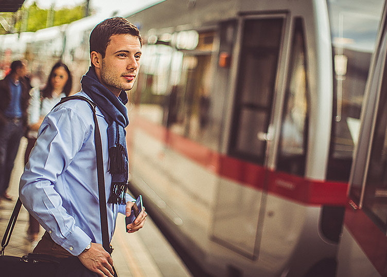 A man in a scarf waiting to get on a train at the Bart Caltrain Station