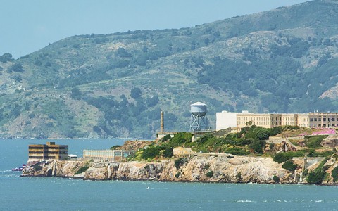 a body of water with the island of the buildings of Alcatraz in the distance