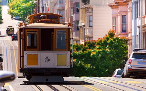 Street view of a cable car and colorful buildings