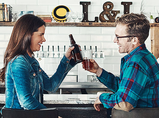 Man and woman clinking glasses of beer