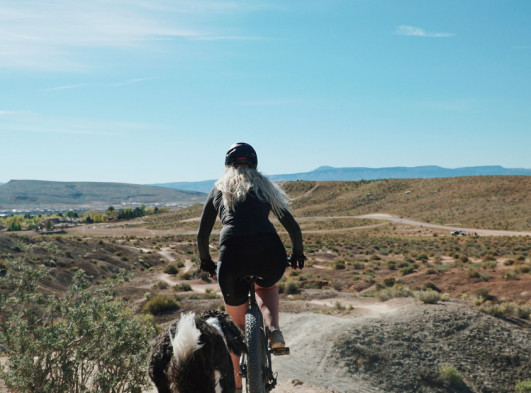 Woman Mountain Biking with Dog
