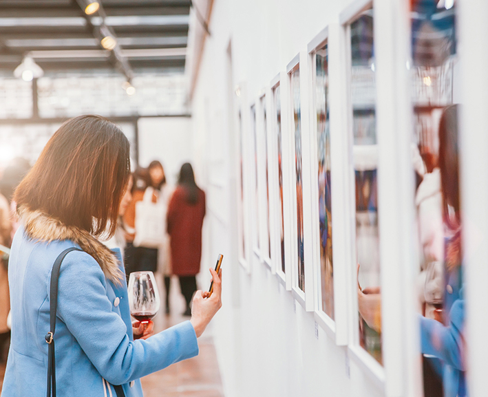 A woman taking a picture of a painting