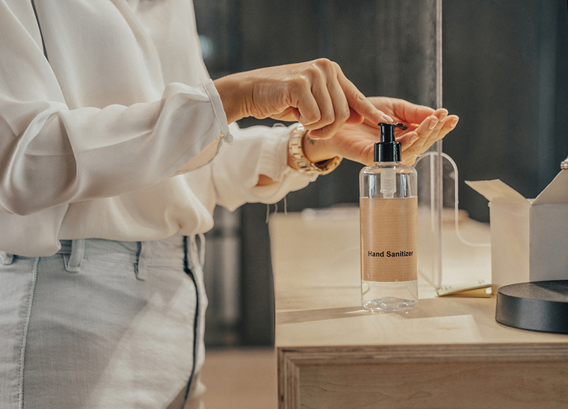 View of a woman using hand sanitizer