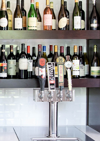 Closeup of a shelf with lots o wine bottles on top