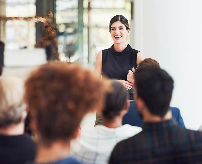 A woman speaking in front of a group of people