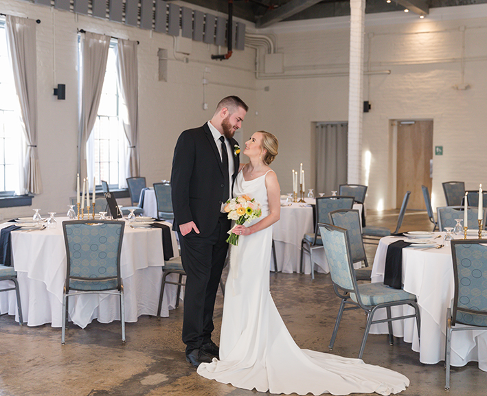 A bride and a groom looking at each other at their wedding venue