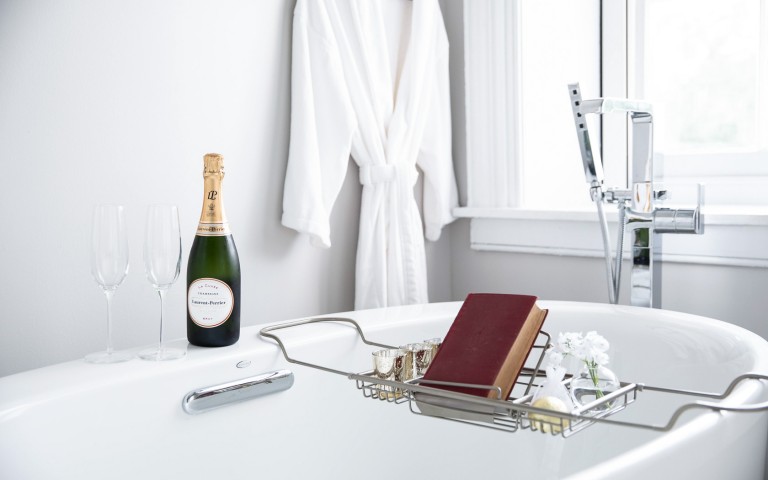 View of an elegant bathtub and a bottle of champaign 