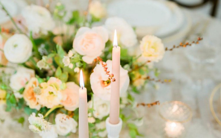 Side view of a table with roses and some pink candles