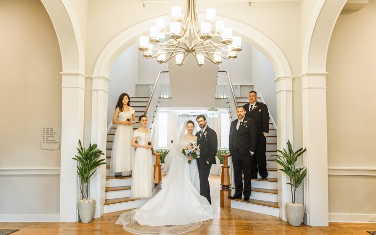 View of a bride and a groom in the middle of two staircases  