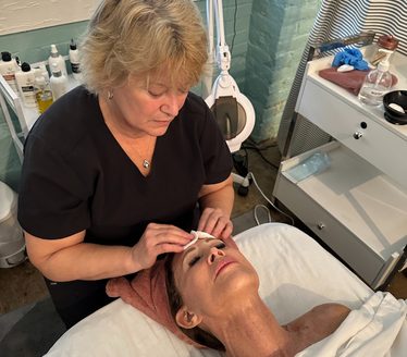 Woman giving a client a facial treatment in a spa