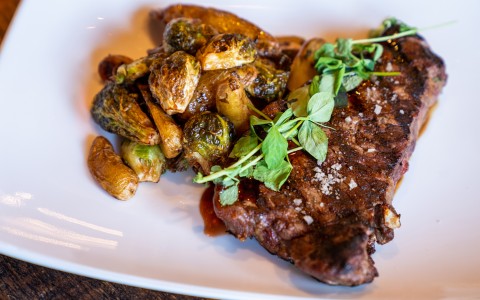 steak dish with roasted brussel sprouts on the side
