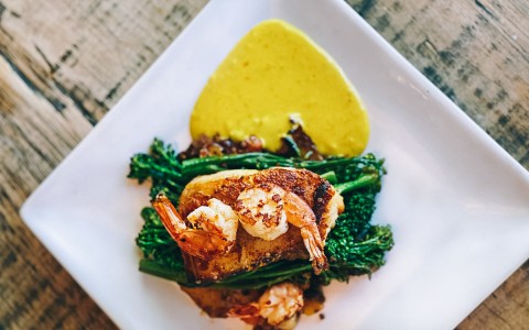 plate with broccolini, shrimp and a yellow sauce